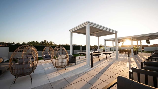Wicker chairs tables pergolas outdoor lounge area at NOVA Tallahassee in Tallahassee Student Accommodation