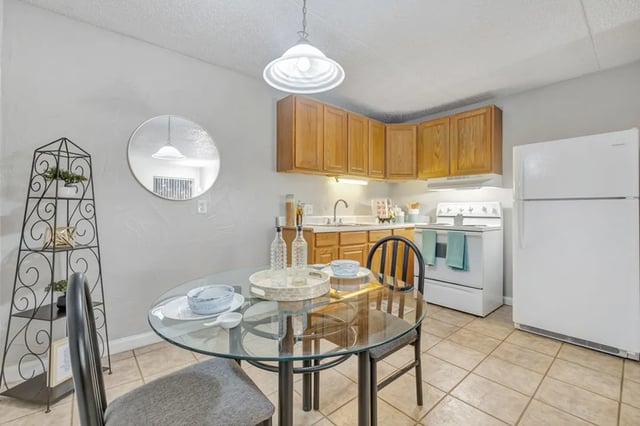 Glass table with chairs and kitchen appliances kitchen at Campus Walk Tallahassee in Tallahassee Student Accommodation