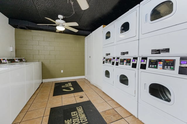 Stackable washers and dryers with payment consoles laundry area at Campus Walk Tallahassee in Tallahassee Student Accommodation