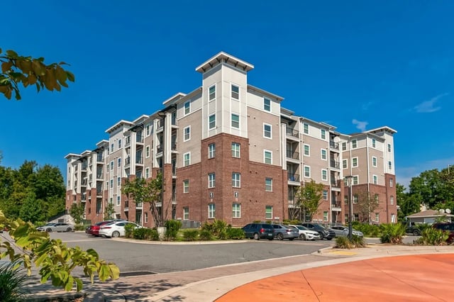 Apartment building with balconies and parking lot exterior at Oktiv in Tallahassee Student Accommodation