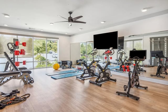 Spin bikes weight bench yoga mats exercise room at Oktiv in Tallahassee Student Accommodation