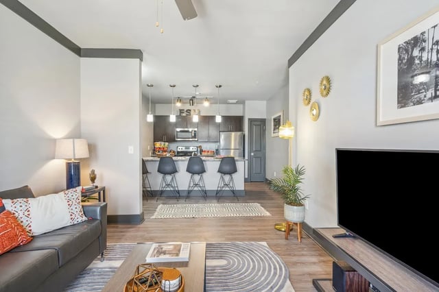 Sofa kitchen island bar stools television living room kitchen at Oktiv in Tallahassee Student Accommodation