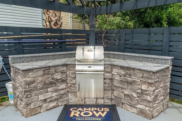 Outdoor kitchen with grill and stone counters exterior at Campus Row Tallahassee in Tallahassee Student Accommodation
