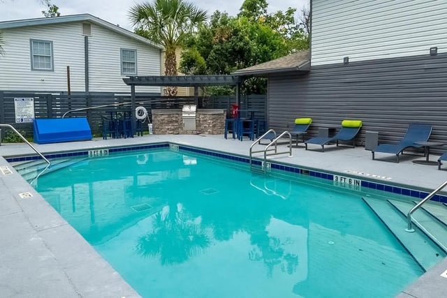 Pool with lounge chairs and outdoor kitchen exterior at Campus Row Tallahassee in Tallahassee Student Accommodation