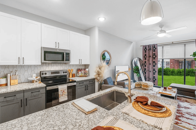 Modern kitchen with granite island and living area kitchen living room at Statehouse Tallahassee in Tallahassee Student Accommodation