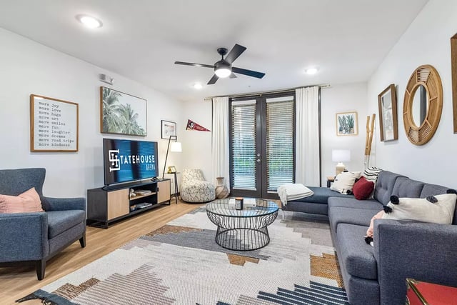 Gray sectional sofa with coffee table and TV living room at Statehouse Tallahassee in Tallahassee Student Accommodation