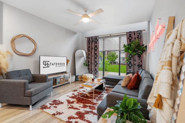 Gray sectional sofa accent pillows area rug living room at Statehouse Tallahassee in Tallahassee Student Accommodation