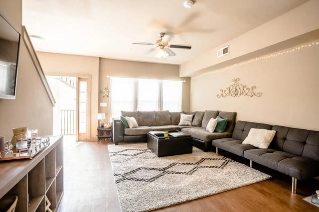 Gray sectional sofa ottoman patterned rug living room at CollegePlace - Avenues I in Tallahassee Student Accommodation