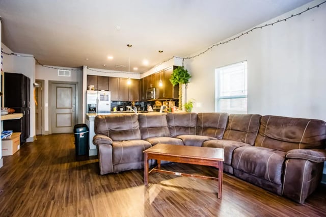 Brown sectional sofa coffee table kitchen living room at CollegePlace - Avenues I in Tallahassee Student Accommodation
