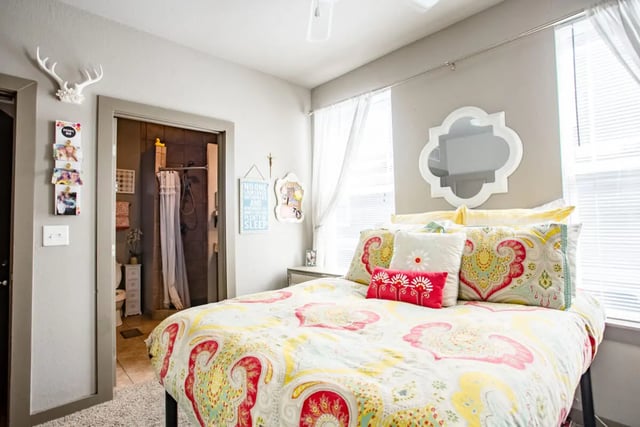 Bed with patterned comforter pillows mirror bedroom at CollegePlace - Avenues I in Tallahassee Student Accommodation