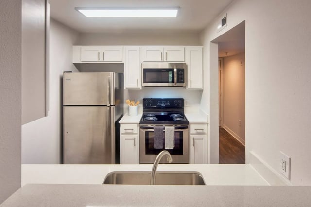 Stainless steel refrigerator stove microwave sink kitchen at The Crossing at Sante Fe in Gainesville Student Accommodation