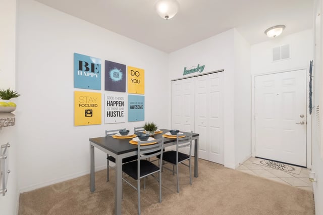 Dining table with four chairs and wall art dining area at The Crossing at Sante Fe in Gainesville Student Accommodation