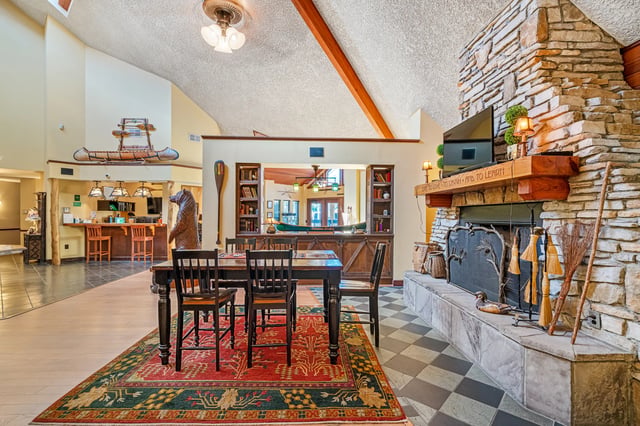 Dining table with chairs by stone fireplace and counter living room at Forest Lake in Lutz Student Accommodation