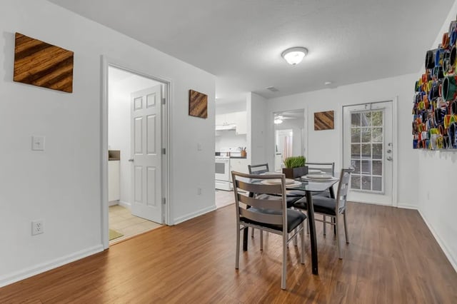 Dining table with chairs and kitchen area dining room at The Preserve at San Luis in Tallahassee Student Accommodation