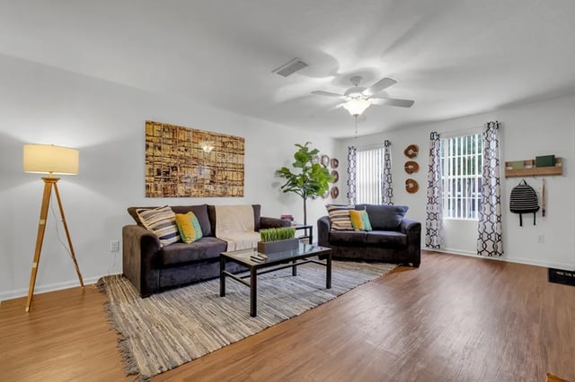 Two sofas coffee table artwork living room at The Preserve at San Luis in Tallahassee Student Accommodation