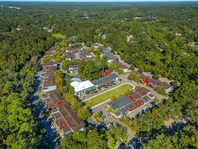 Apartment buildings with red roofs and parked cars exterior at The Preserve at San Luis in Tallahassee Student Accommodation