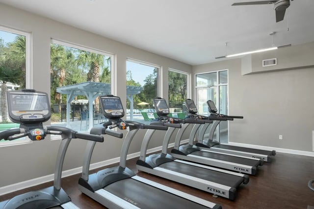 Row of treadmills with screens fitness area at Gainesville Place in Gainesville Student Accommodation