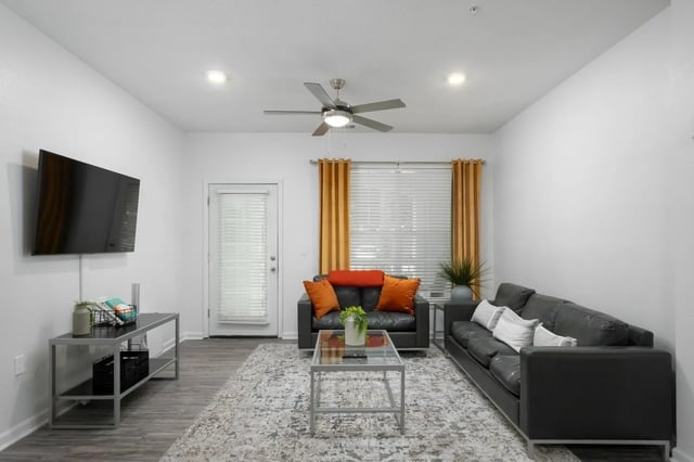 Sofa coffee table rug television and fan living room at Gainesville Place in Gainesville Student Accommodation