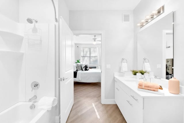 White tub shower vanity with mirror and bed at Park Place Tampa in Tampa Student Accommodation
