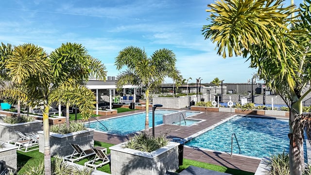 Resort style pools with lounge chairs and palm trees exterior at Park Place Tampa in Tampa Student Accommodation