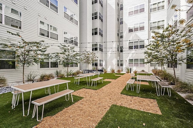 Benches and tables on grass courtyard exterior at Park Place Tampa in Tampa Student Accommodation