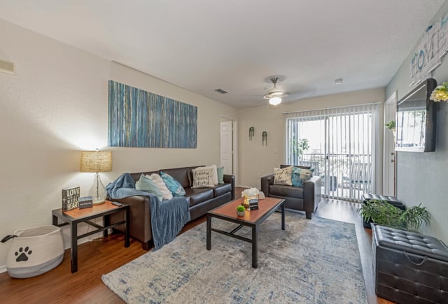 Sofa two chairs coffee table rug living room at College Station Orlando in Orlando Student Accommodation