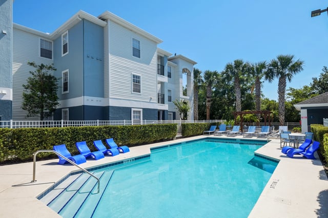 Blue lounge chairs near a pool exterior at College Station Orlando in Orlando Student Accommodation