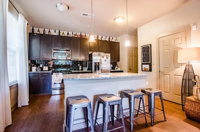 Kitchen with island stools appliances and cabinets kitchen at CollegePlace - Paces in Tallahassee Student Accommodation