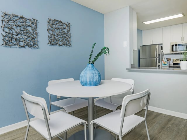White table and chairs with blue vase dining area at Reflections in Tampa Student Accommodation