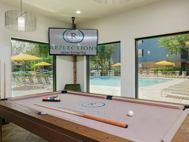 Pool table with rack and cue by pool lounge area game room at Reflections in Tampa Student Accommodation