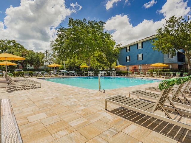 Pool lounge chairs with yellow umbrellas exterior at Reflections in Tampa Student Accommodation