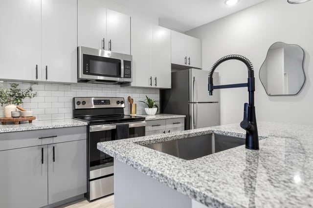 Modern kitchen with stainless steel appliances and granite countertops kitchen at The 9 UCF in Orlando Student Accommodation