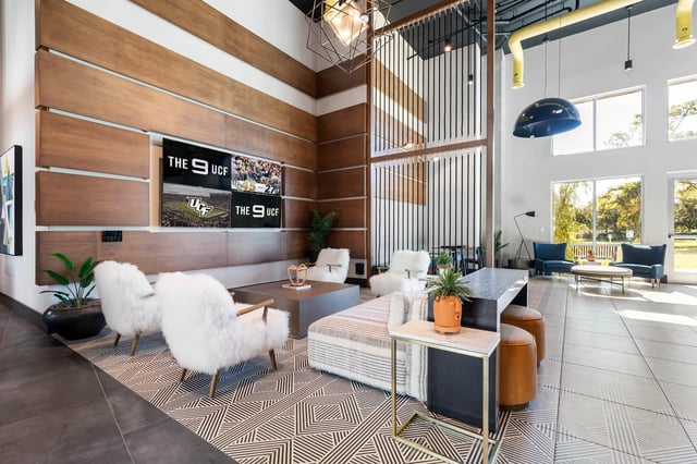 Wood paneling screens sofas chairs and tables common area at The 9 UCF in Orlando Student Accommodation