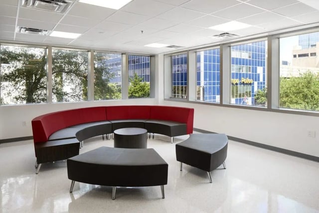 Curved red sofa round table ottoman living room at 220 Madison in Tampa Student Accommodation