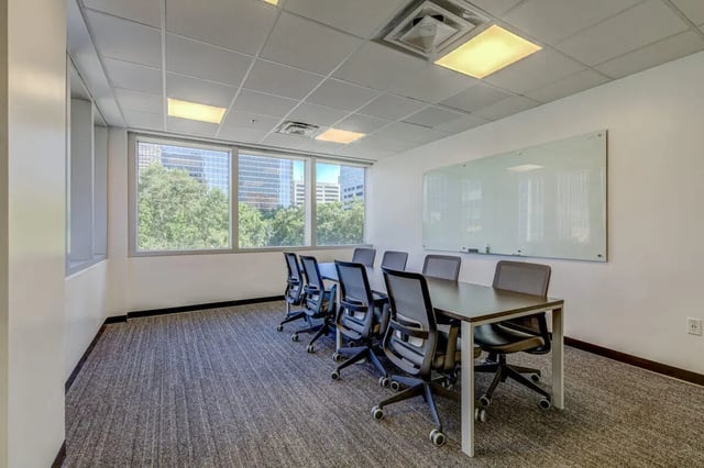 Table and chairs with whiteboard meeting room at 220 Madison in Tampa Student Accommodation