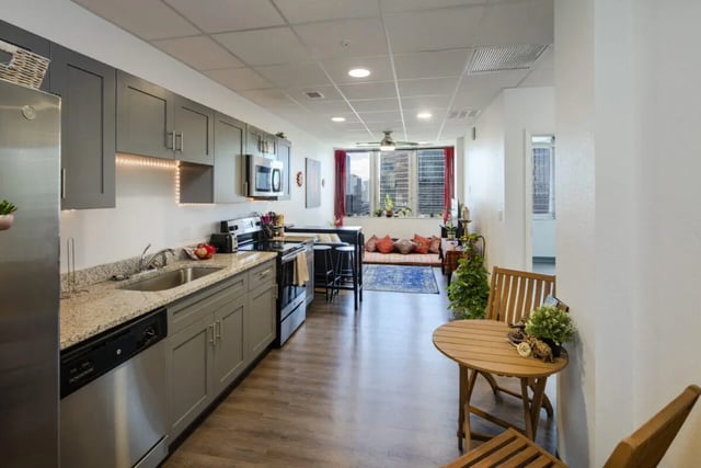 Modern kitchen with seating area and living space living room at 220 Madison in Tampa Student Accommodation
