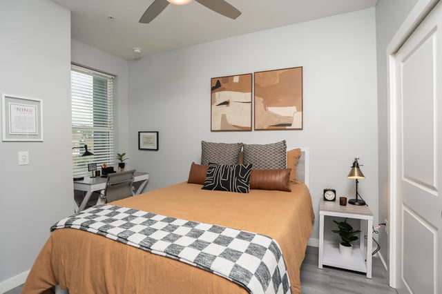 Bed desk artwork and ceiling fan bedroom at The Nine at Tallahassee in Tallahassee Student Accommodation