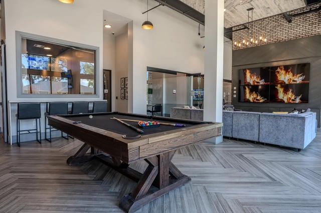 Pool table with balls cues bar stools lounge living room at The Nine at Tallahassee in Tallahassee Student Accommodation