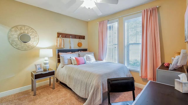 Bed bedside table lamp mirror and desk Bedroom at Lyons Corner Apartments in Gainesville Student Accommodation