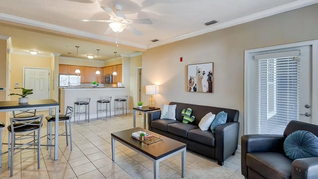Sofa coffee table bar stools and kitchen living room at Lyons Corner Apartments in Gainesville Student Accommodation