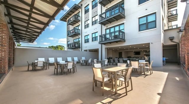 Tables chairs covered patio with outdoor kitchen exterior at FSU Collegetown in Tallahassee Student Accommodation