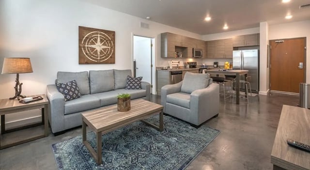 Sofa chair coffee table kitchen living room at FSU Collegetown in Tallahassee Student Accommodation