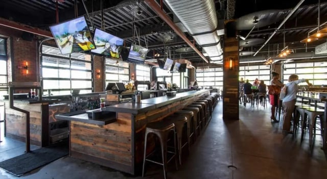 Long bar with stools and televisions interior area at FSU Collegetown in Tallahassee Student Accommodation