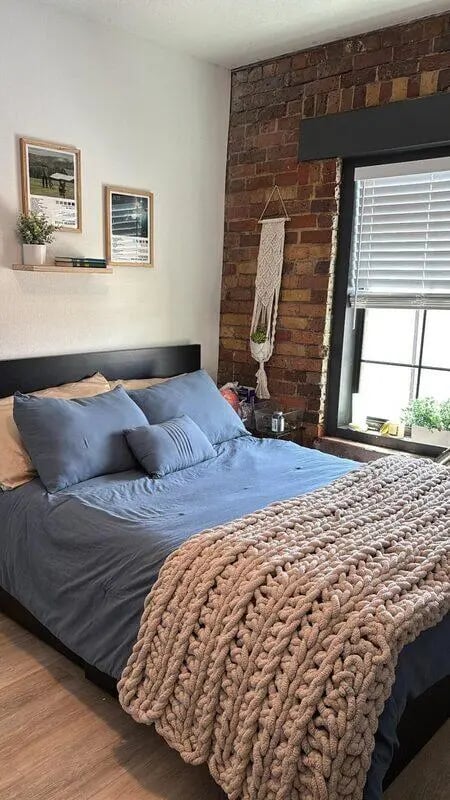 Bed with blue bedding plush throw framed art Bedroom at CigarLofts in Tampa Student Accommodation