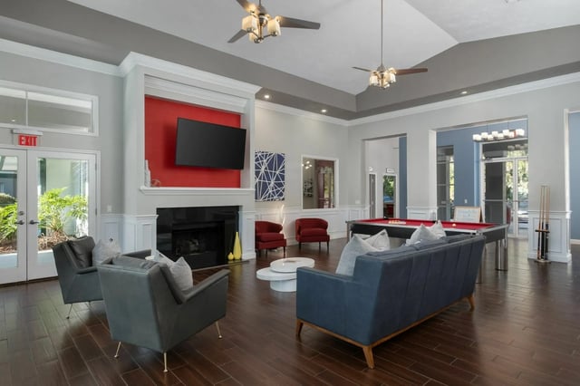 Sofas fireplace pool table and chairs lounge area at The Landings Gainesville in Gainesville Student Accommodation