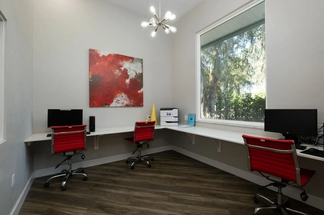 Computers red chairs printer large window study area at The Landings Gainesville in Gainesville Student Accommodation