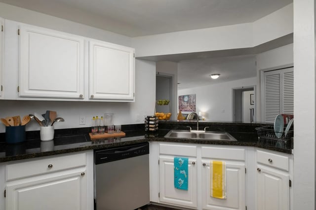 White cabinets dishwasher sink utensils and fruit bowl kitchen at The Landings Gainesville in Gainesville Student Accommodation