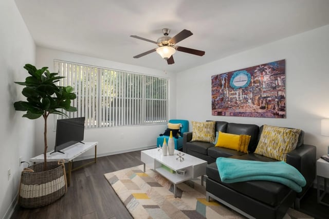Black sectional sofa with yellow pillows living room at The Landings Gainesville in Gainesville Student Accommodation