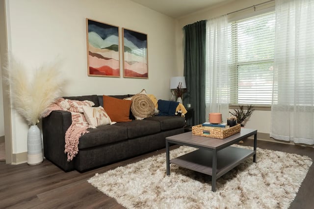 Sofa with pillows and plants in living room at Saga Tallahassee in Tallahassee Student Accommodation