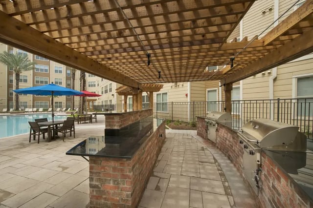 Outdoor grills and bar area with swimming pool. Exterior. at Saga Tallahassee in Tallahassee Student Accommodation